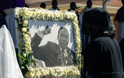 Former first lady Grace Mugabe walks past a portrait of Robert Mugabe during the burial of the former Zimbabwe leader at his home village in Kutama, west of the capital Harare