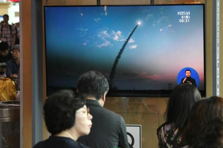 People watch a television news screen showing a file footage of North Korea's missile launch, at a railway station in Seoul on August 6, 2019