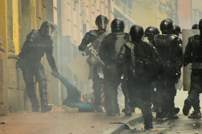 Riot police arrest a demonstrator during a protest following the announcement of a transport strike against Ecuadorean President Lenin Moreno's government economic policies