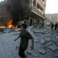 A young boy runs past a fire started in a building following a reported airstrike by Syrian regime forces in the town of Maaret al-Noman in Syria's northwestern Idlib province on August 28, 2019
