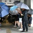 Protesters covered themselves with umbrellas as they gathered outside the Eastern District Courts in Hong Kong