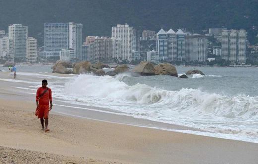 A lifeguard walks along the beach in Acapulco, Mexico on September 18, ahead of Lorena's expected arrival