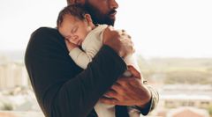 Newborn baby boy in his father's arms