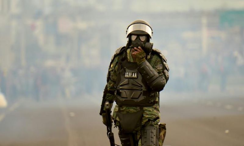 A soldier takes up position during clashes with indigenous people and farmers protesting against fuel hikes introduced by Ecuador's President Lenin Moreno, on the outskirts of Quito