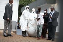 Police carry away Cohen's body which was retrieved from an underground water storage tank