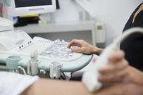 Technician treating varicose veins with ultrasound equipment