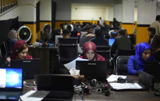 Members of presidential candidate Ashraf Ghani's campaign team answer phone calls at his headquarters in Kabul. His main rival, Abdullah Abdullah, has claimed victory in the vote, even though official results are not due for weeks