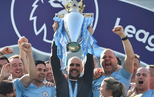 Manchester City manager Pep Guardiola holds the Premier League trophy