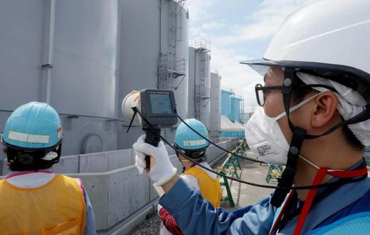 Staff measure radiation levels around the storage tanks of radiation-contaminated water at the tsunami-crippled Tokyo Electric Power Company (TEPCO) Fukushima Dai-ichi nuclear power plant in Japan