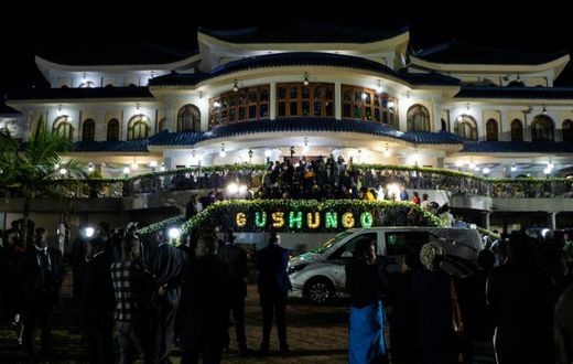 Mourners gather for a funeral wake as the casket of late Zimbabwean President Robert Mugabe arrives at his former Blue Roof residence in Harare