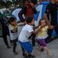 Migrants shield their mouths from tear gas during clashes at the Moira refugee camp