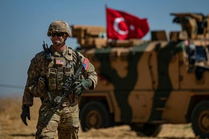 A US soldier stands guard during a joint patrol with Turkish troops in northeastern Syria