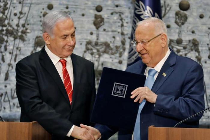 Israeli President Reuven Rivlin gives veteran incumbent Benjamin Netanyahu the potentially impossible task of forming a majority coalition while battling the looming threat of corruption charges