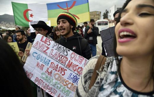 Protesters carry the Algerian flag (L) and the Berber colours side by side at a rally in March against veteran president Abdelaziz Bouteflika in the city of Bejaia east of the capital Algiers