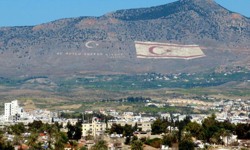 The Kyrenia mountain range, in the north of Cyprus, daubed with the Turkish flag and a quote by Turkey's late founder Ataturk, overlooks the island's divided capital of Nicosia, and can be plainly seen on the Greek Cypriot side