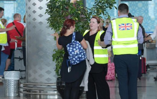 British officials talk to tourists booked with Thomas Cook as they wait for repatriation flights from Enfidha airport on the outskirts of the Tunisian coastal resort of Sousse