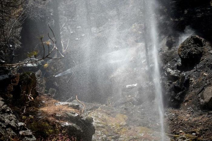 A firefighter douses a forest affected by wildfires in Gran Canaria on the Spanish Canary Islands on August 13, 2019