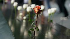 People leave flowers during the September 11 Commemoration Ceremony at the 9/11 Memorial at the World Trade Center on September 11, 2019,in New York.