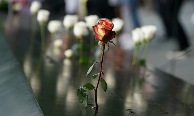 People leave flowers during the September 11 Commemoration Ceremony at the 9/11 Memorial at the World Trade Center on September 11, 2019,in New York.