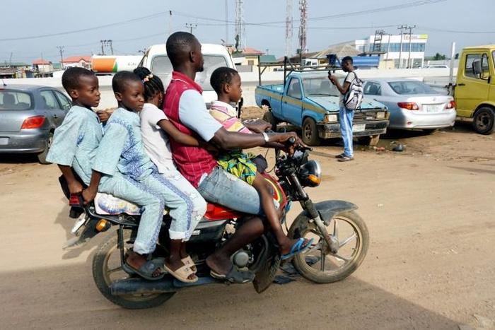 Room for one more? A traditional motorcycle taxi on Lagos roads -- overladen and not a crash helmet in sight