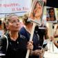 A woman holds the picture of a victim as she takes part in a protest march denouncing violence against women in Paris