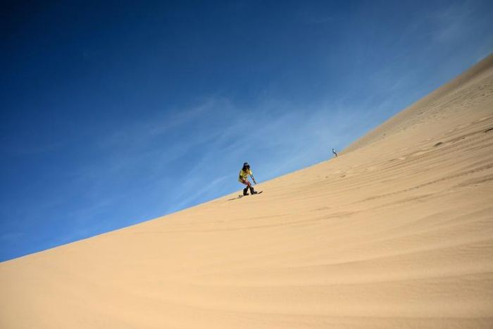 Sun-kissed and shaggy haired, Nguyen Thai Binh swaps his flip flops for bulky boots ahead of snowboarding practice on the sand dunes of southern Vietnam -- the unlikely training ground for the country's fledgling winter athletes