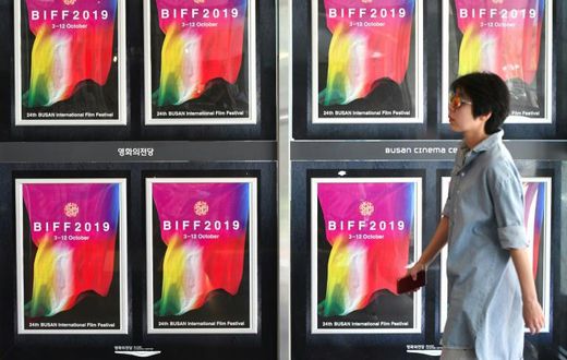 A woman walks past posters for the Busan International Film Festival at the Busan Cinema Center in South Korea