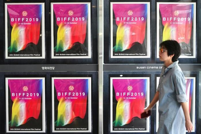 A woman walks past posters for the Busan International Film Festival at the Busan Cinema Center in South Korea