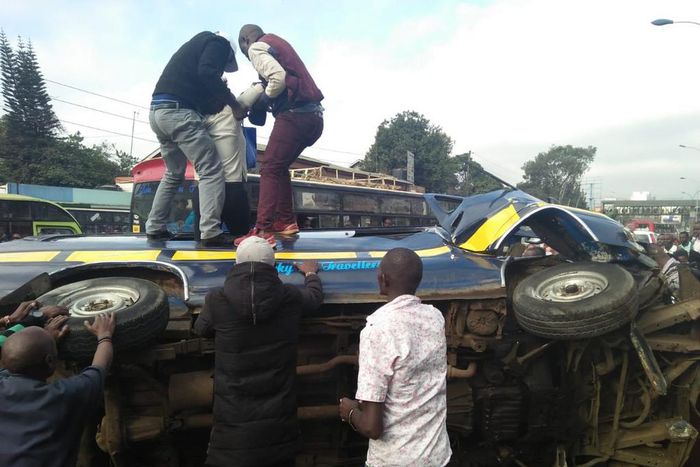 Members of the public assist passengers on 14-seater matatu that overturned at Ngara along Murang'a Road
