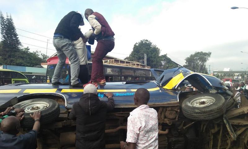 Members of the public assist passengers on 14-seater matatu that overturned at Ngara along Murang'a Road