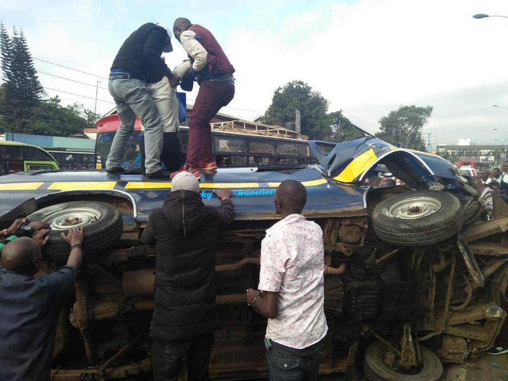 Members of the public assist passengers on 14-seater matatu that overturned at Ngara along Murang'a Road