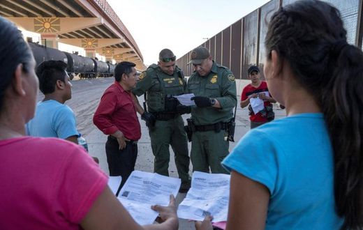 US Customs and Border Protection agents in May 2019 check documents in El Paso, Texas, from a small group of migrants who crossed from Mexico