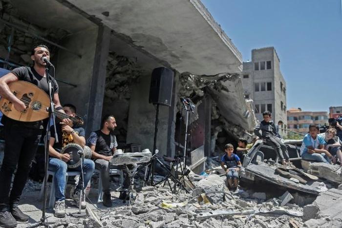 The Palestinian band Dawaween performs on May 14, 2019 on the rubble of a building in the Gaza Strip that was recently destroyed by Israeli air strikes during an event calling for a boycott of the Eurovision song contest hosted by Israel