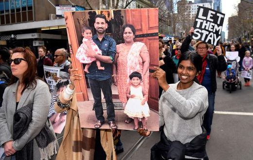 Protesters hold up placards in Melbourne during a rally in support of the Tamil refugee family