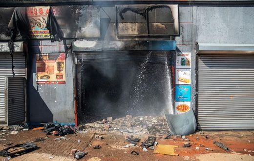 Attacked: The remains of a store in Johannesburg's Malvern area after a night of violence
