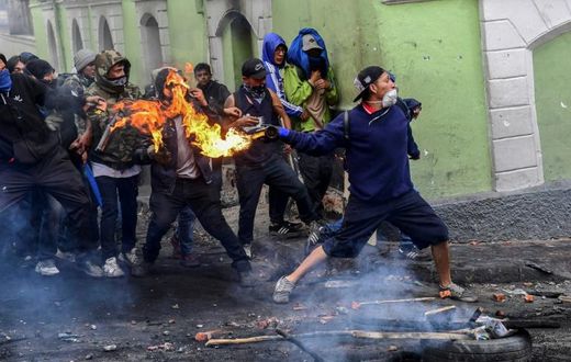 Demonstrators clash with riot police in Quito. The protestors are demanding the president reinstate fuel subsidies which were cut last week