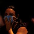 A woman covers her face with a surgical mask to protect herself from the smoke during a fire at the Badim hospital in Rio de Janeiro