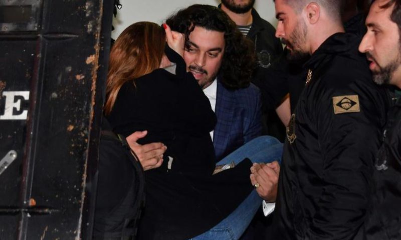 The woman who has accused Brazilian football star Neymar of rape, Najila Trindade Mendes de Souza, is carried out of a Sao Paulo police station by her lawyer Danilo Garcia de Andrade -- he has now abandoned her as a client