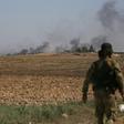 Turkish-backed Syrian fighters watch as smoke billows from the Syrian border town of Tal Abyad