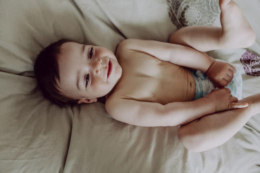 Happy baby, lying on bed, laughing