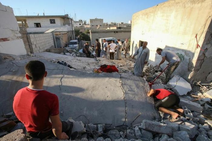 Syrian civilians search for survivors under the rubble of a building following a reported airstrike by Syrian regime forces in Maar Shurin on the outskirts of Maaret al-Numan in northwest Syria's Idlib province