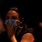 A woman covers her face with a surgical mask to protect herself from the smoke during a fire at the Badim hospital in Rio de Janeiro