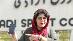 Iranian sports journalist Raha Pourbakhsh shows purchased electronic tickets for the Iran-Cambodia World Cup 2022 match in front of Azadi stadium in the capital Tehran