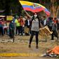 A demonstrator waves an Ecuadoran flag during clashes with riot police amid protests over a fuel price hike ordered by the government to secure an IMF loan on October 12, 2019