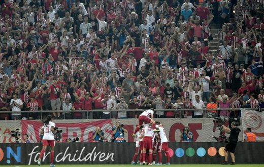 Olympiakos players and fans celebrate Mathieu Valbuena's equaliser against Tottenham