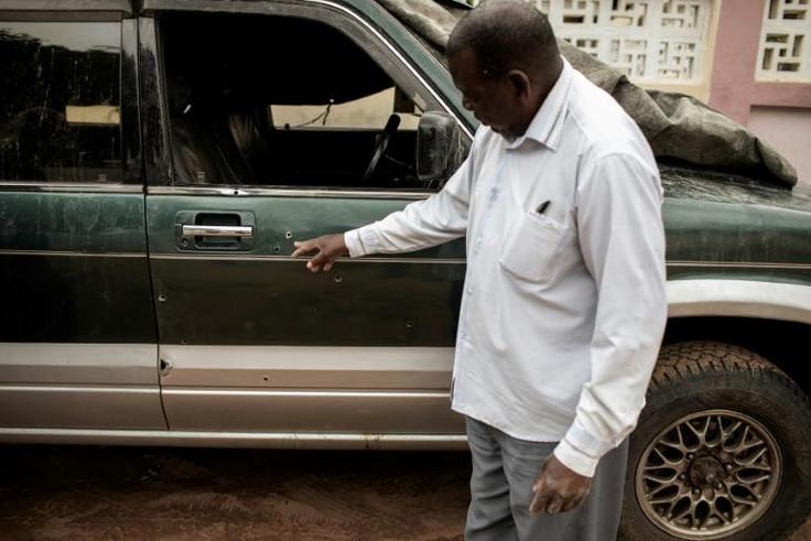 Filipe Mahanjane points to bullet holes in the car where election observer Anastacio Matavele was slain in Xai-Xai, Mozambique