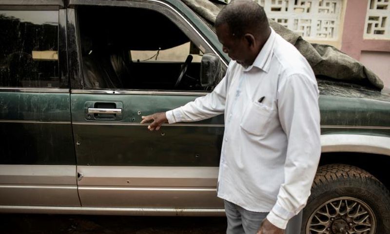 Filipe Mahanjane points to bullet holes in the car where election observer Anastacio Matavele was slain in Xai-Xai, Mozambique