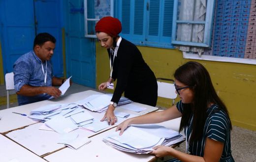 Tunisian volunteers count ballots at a polling station in Sousse, south of the capital Tunis