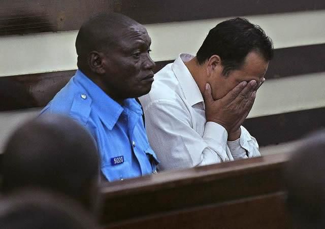 A Chinese national arraigned in court accompanied by a Kenyan police officer (Twitter)
