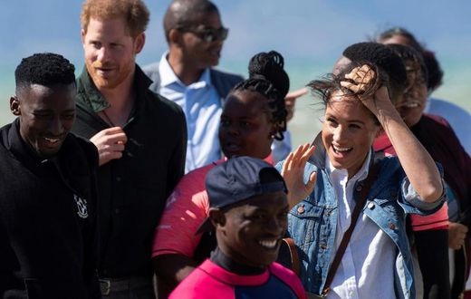 Wind and smiles: Prince Harry and his wife Meghan meet members of Waves for Change. The group uses surfing to help young people trapped in Cape Town's slums get a different perspective on life